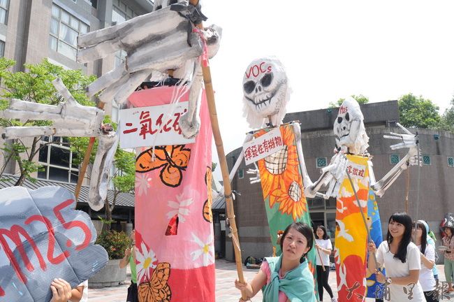 PM2.5街頭「偶巷」劇以各類環保廢材，打造大型人偶，以行動劇告訴鎮民空氣品質的重要。（柏原祥攝）